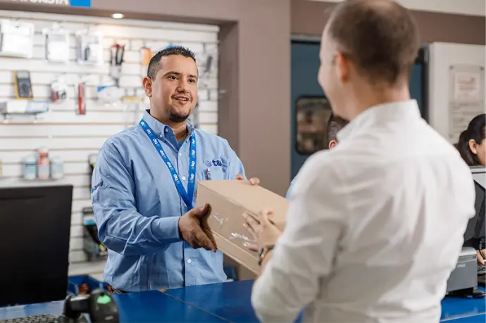 Vendedor de sucursal entregando paquete de producto a cliente